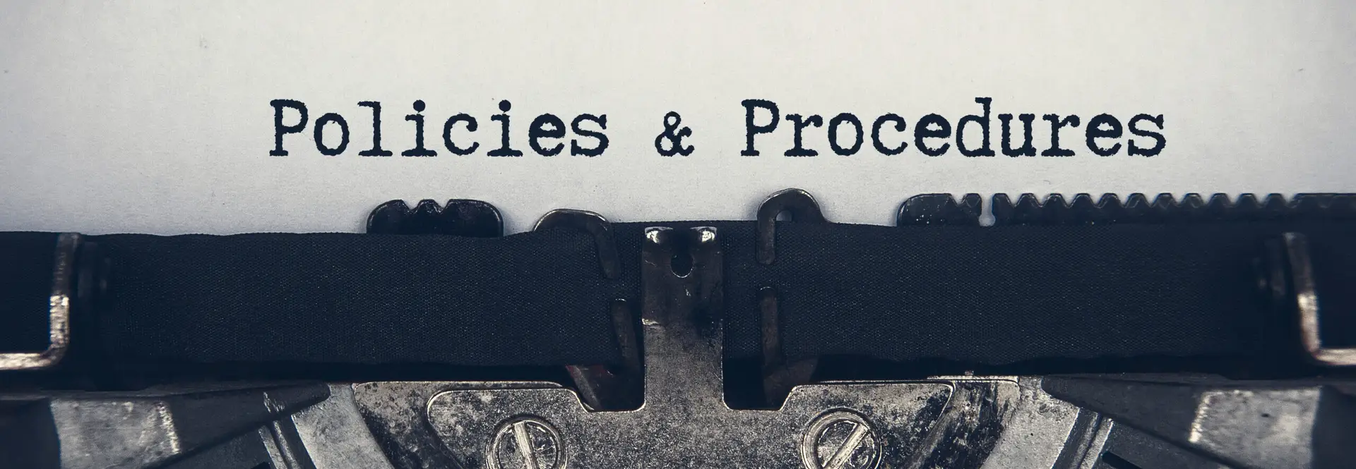 Policies and procedures text typed on an old vintage typewriter.